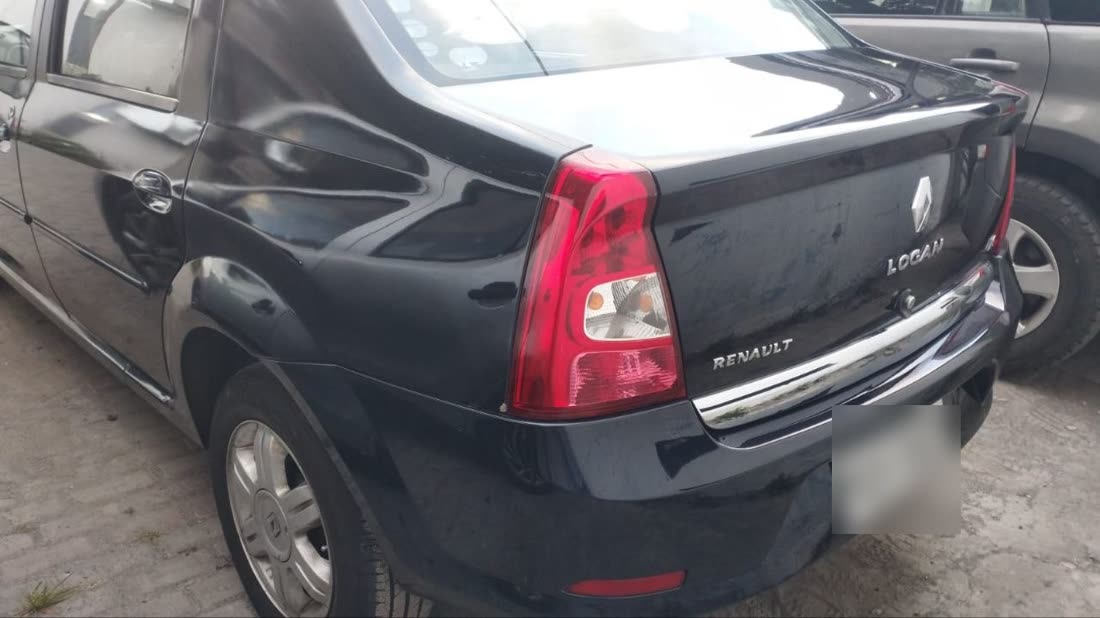 Vista lateral del mismo Renault Logan, con la puerta y la aleta trasera hundidas