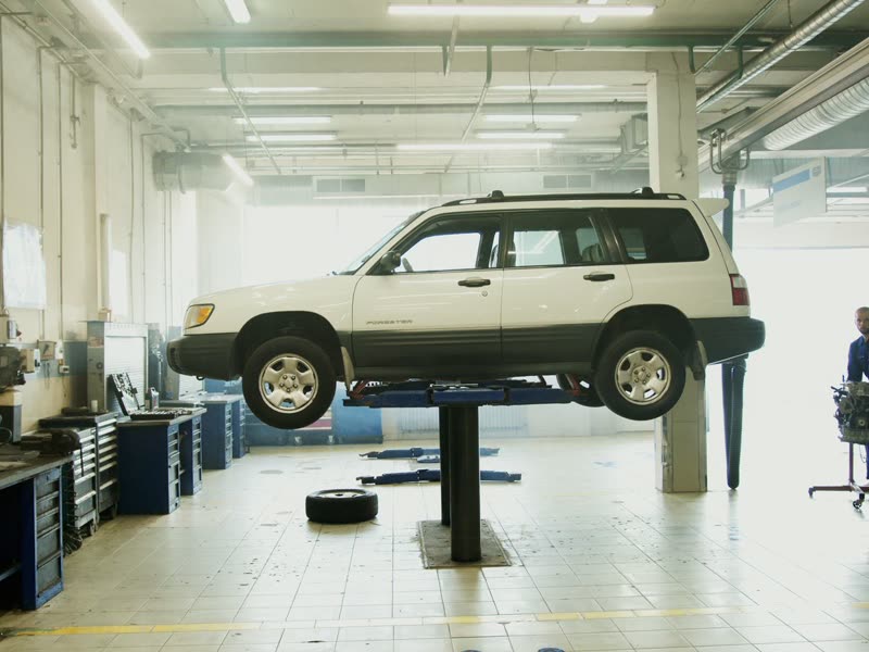 Nave del taller con un vehículo elevado sobre el puente hidráulico